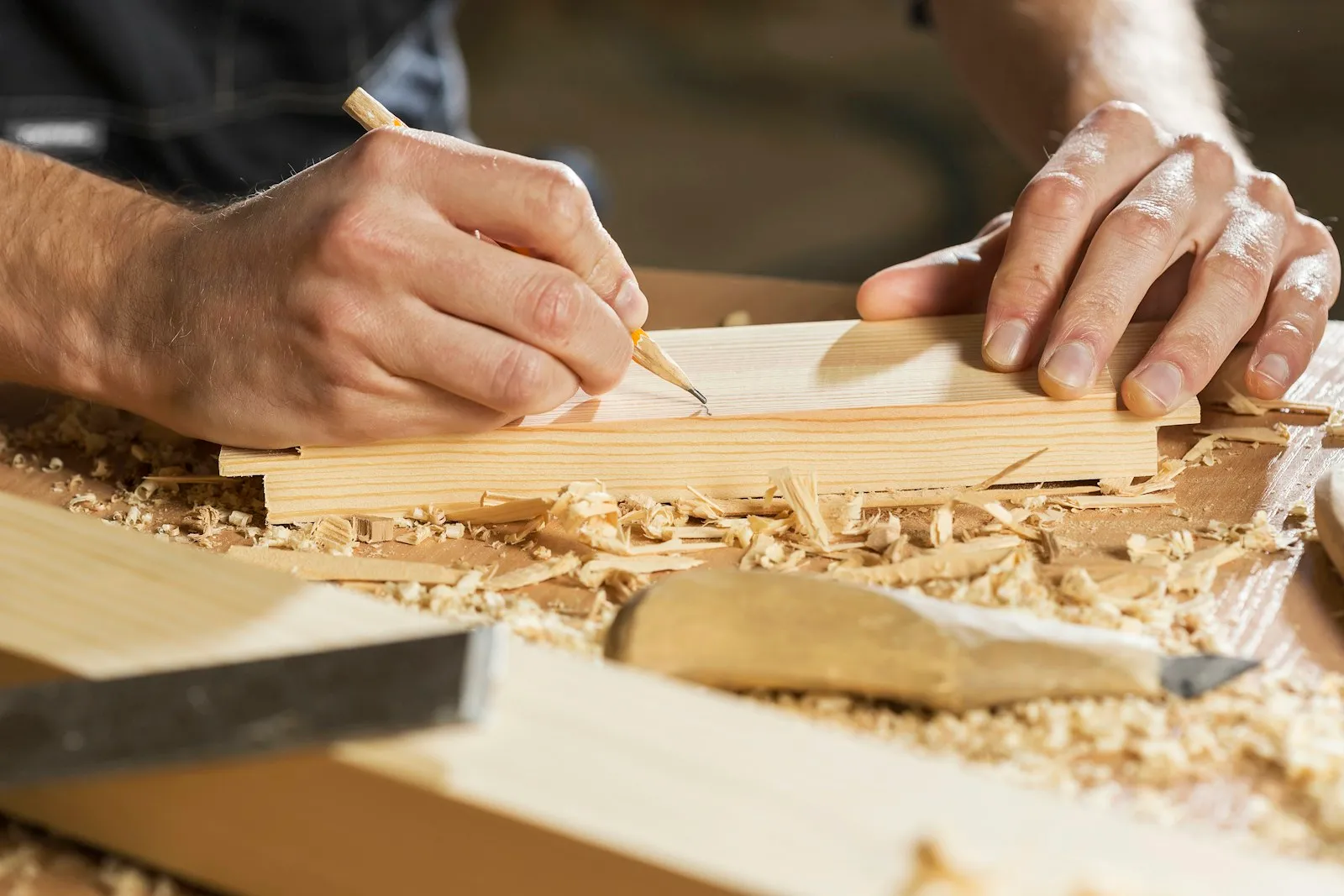 Artisan menuisier traçant une coupe sur une planche