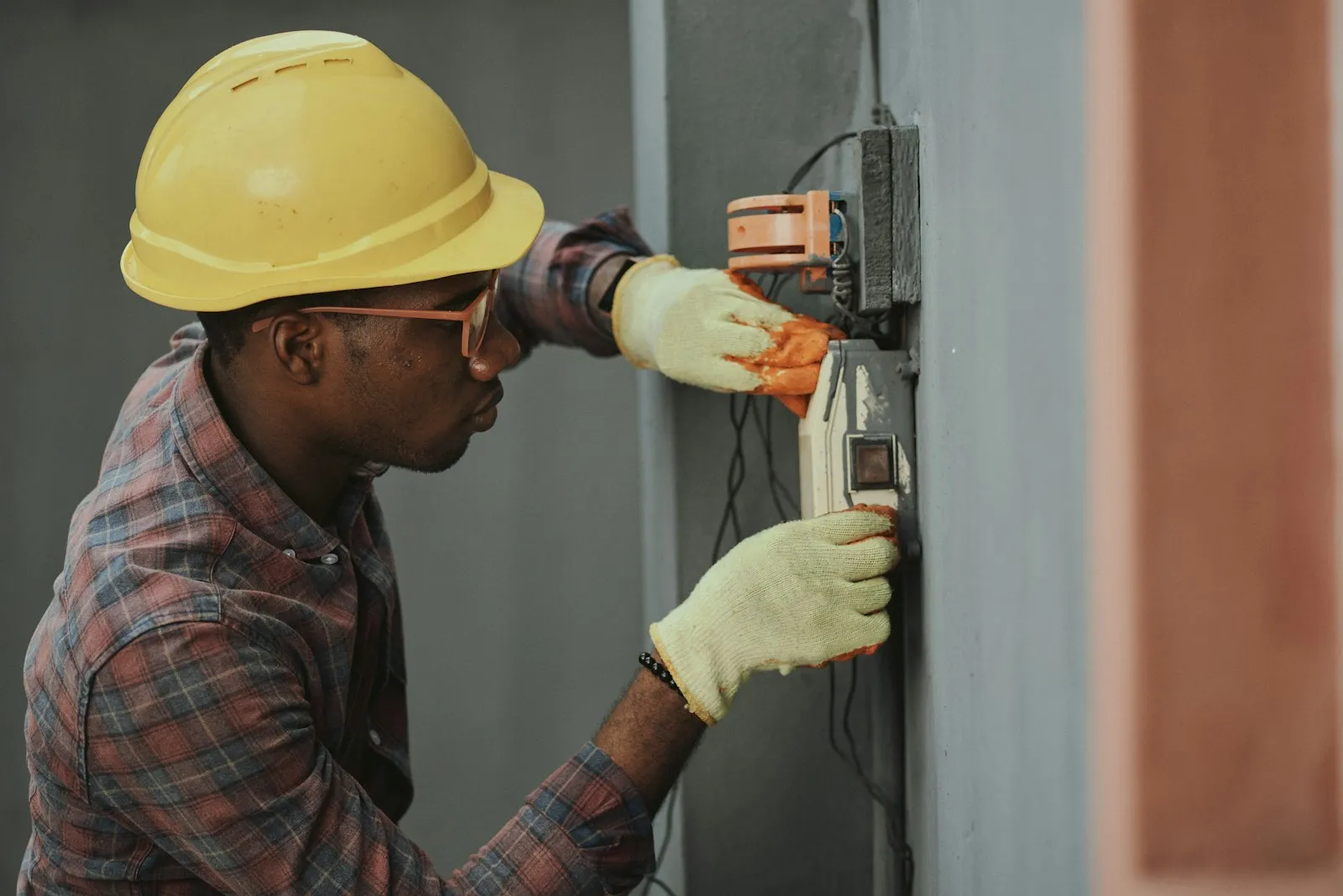 Électricien avec son casque installant un équipement électrique