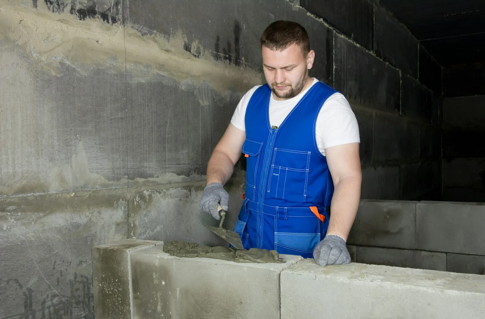 Maçon en gilet de travail sur un chantier