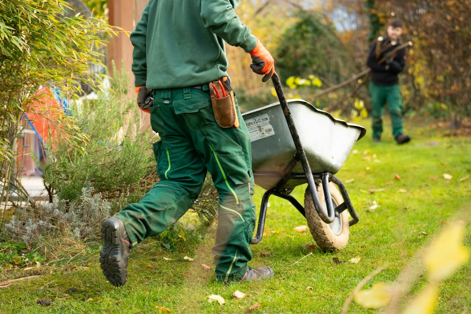Paysagistes au travail dans un jardin avec une brouette