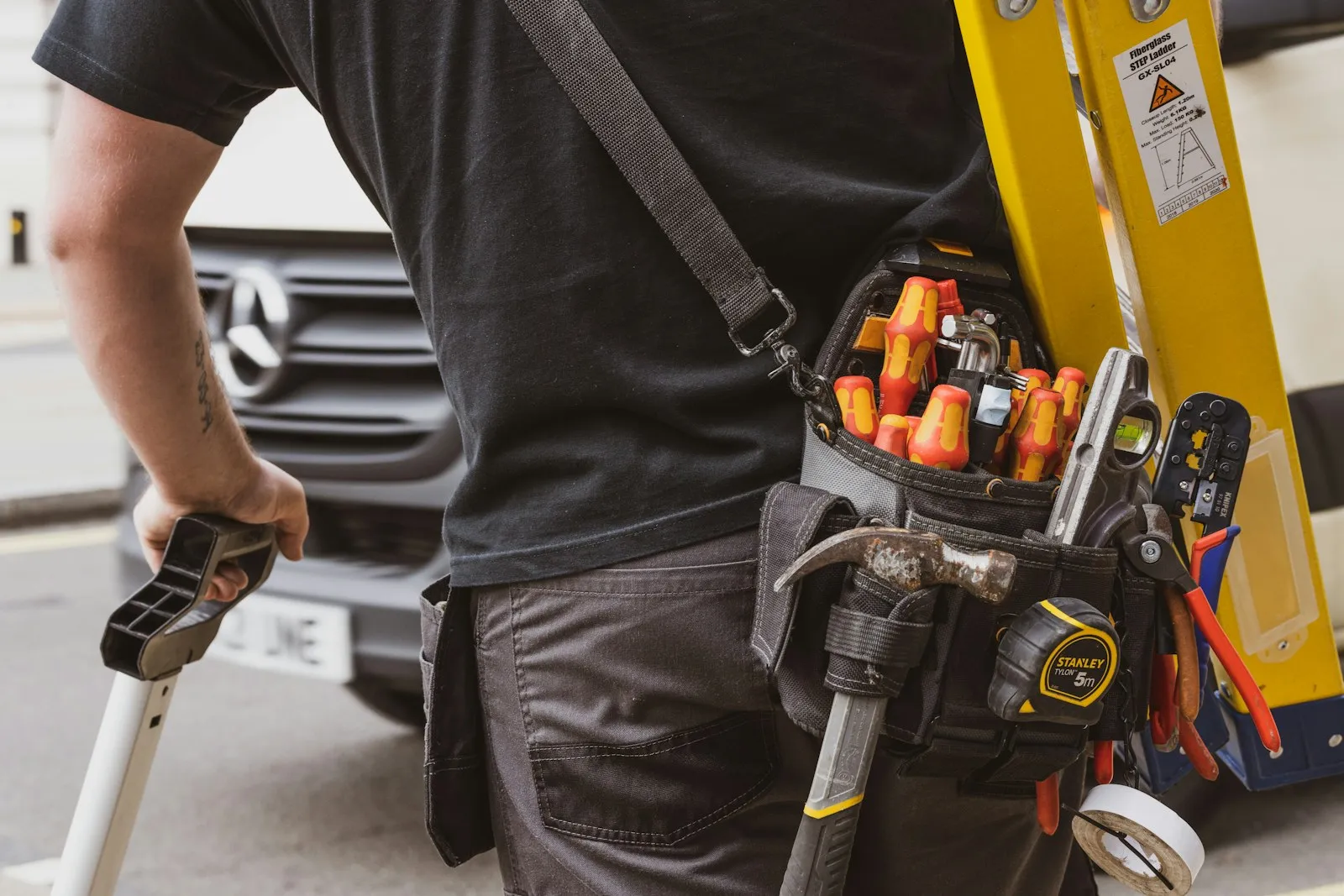 Technicien avec sa ceinture d'outils se rendant sur une intervention