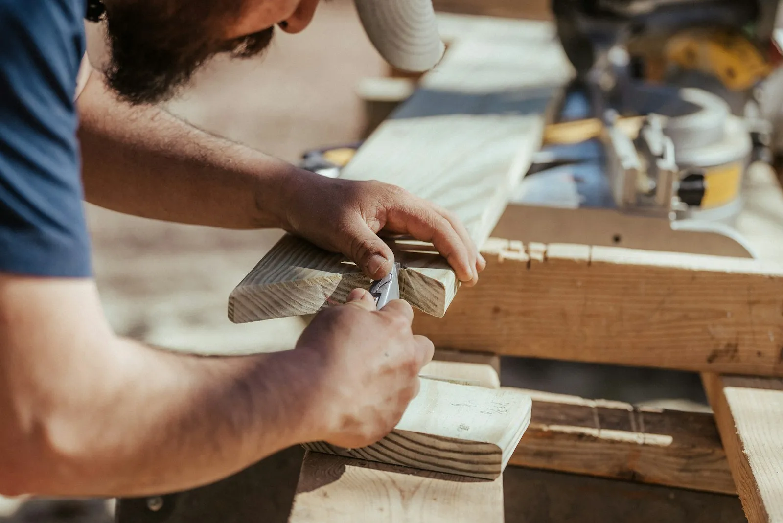Menuisier travaillant une pièce de bois dans son atelier